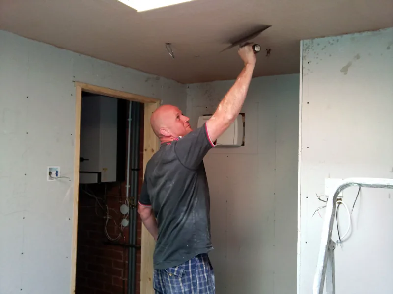 Tradesman finishing ceiling plaster during one of David’s domestic refurbishment projects